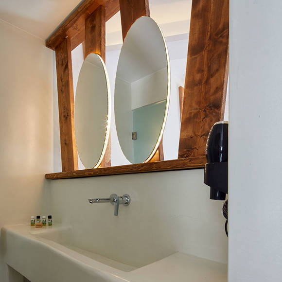 Santorini View Hotel bathroom with two mirrors and wooden decoration, and bath amenities
