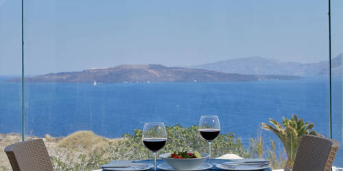 
Santorini View Hotel caldera view restaurant with table seats, red wine and greek salad