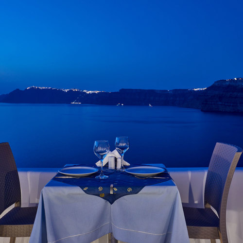  
Santorini View Hotel caldera view restaurant, exterior table seats at night 