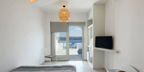 
Santorini View Hotel bedroom with double bed and tv, with balcony with aegean sea view