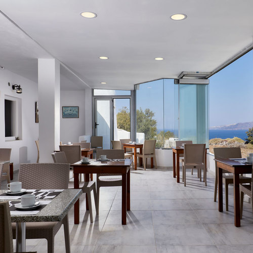  
Santorini View Hotel interior of the restaurant with brown table seats and sea view