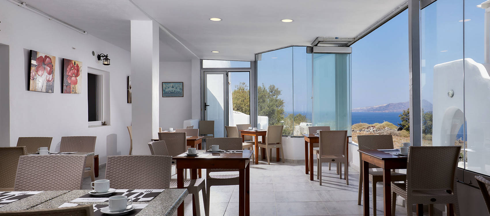 
Santorini View Hotel εσωτερικό του εστιατορίου με καφέ τραπεζοκαθίσματα και θέα στη θάλασσα