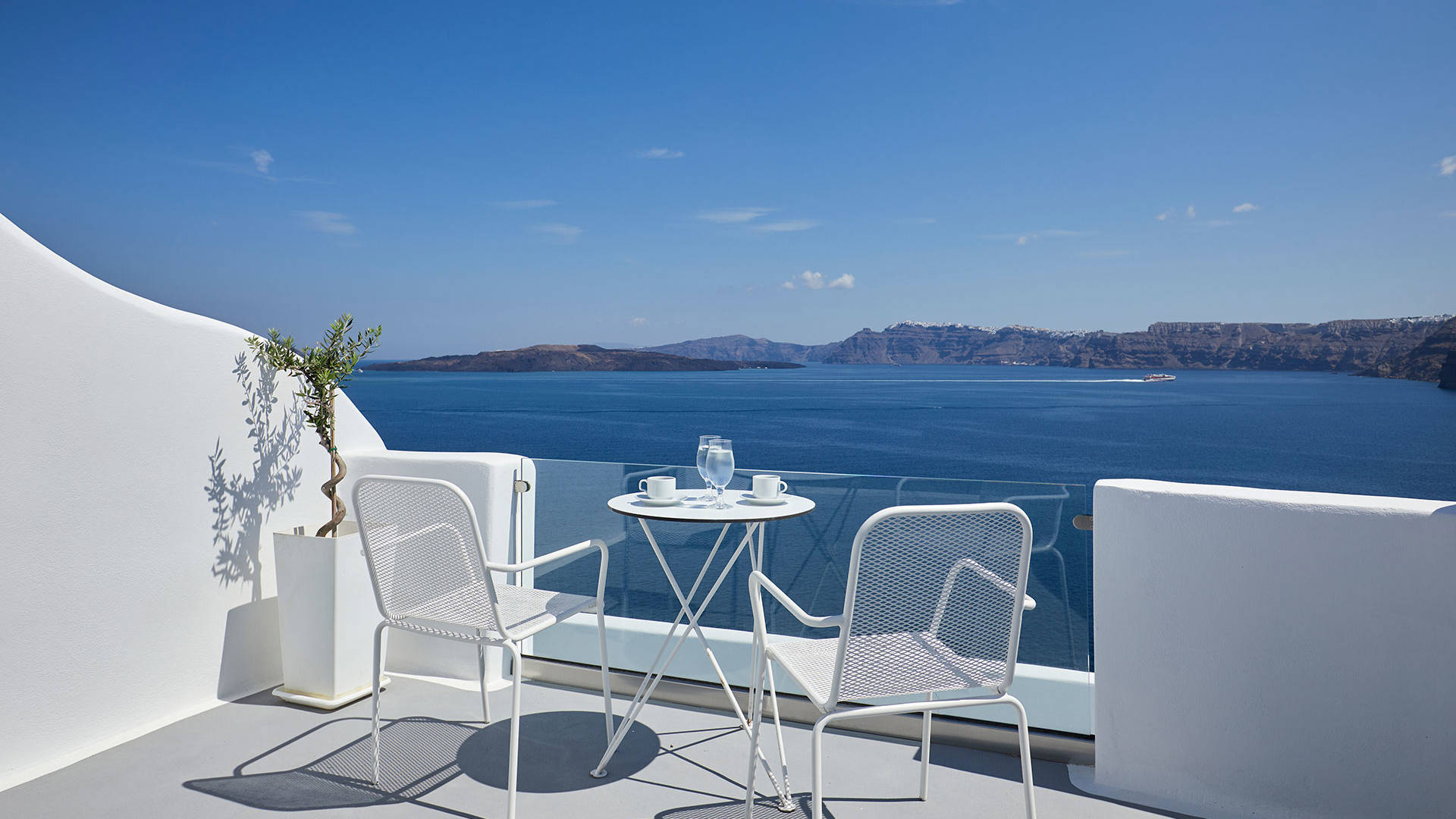 
Santorini View Hotel balcony in white colors with furniture and view at the aegean sea