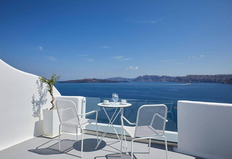 
Santorini View Hotel balcony in white colors with furniture and view at the aegean sea