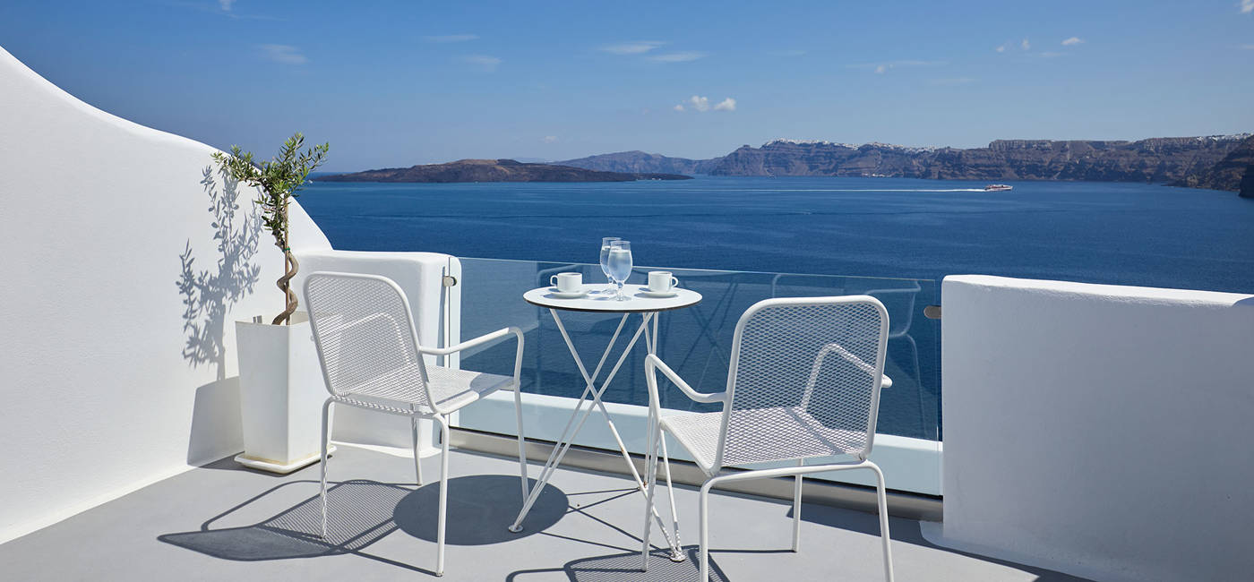 
Santorini View Hotel μπαλκόνι σε λευκά χρώματα με έπιπλα και θέα στο Αιγαίο